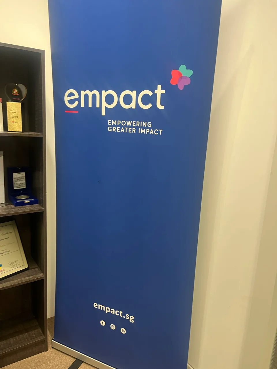 办公室的蓝色 Empact 品牌墙与展示柜一角