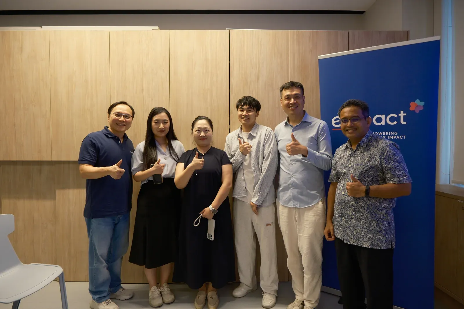 波克公益与 Empact 活动参与者在 Empact 展架旁合影